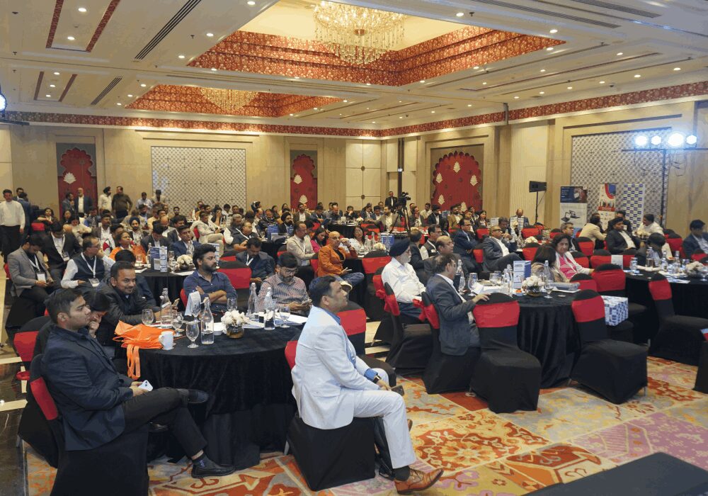 Guests seated at round tables in a packed conference ballroom